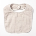 Detail view of cotton gauze baby bib featuring soft wrinkled texture and snap fasteners - Gray