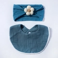 Detail of dark blue muslin baby bib with pom-poms and matching floral headband set - Navy Blue