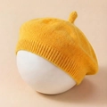 Close-up of bright yellow knitted baby beret with sprout top and ribbed elastic edge - Yellow