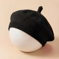 Detail of black knitted baby beret showing the ribbed edge and small top stalk design - Black