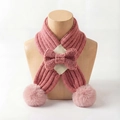 Detailaufnahme des rosa Strickschals für Babys mit Schleife und flauschigen Bommeln - Altrosa
