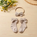Baby cotton headband and bow socks set on wooden desk with floral decor detail - Gray