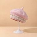 Nahaufnahme der rosa Strickmütze für Babys mit feiner Spitze und weicher Textur - Rosa