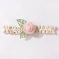 Dettaglio della fascia in pizzo per neonati con rosa di seta rosa e ricamo di foglie - Rosa