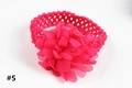 Détail de bandeau bébé avec fleur en mousseline rose vif et texture crochet - Rose rouge
