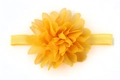 Dettaglio ravvicinato di una fascia elastica gialla per neonati con un fiore in chiffon - Giallo ocra