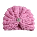 Gros plan sur un bonnet en tricot rose pour bébé avec texture torsadée et broche strass - Réglable / Rose