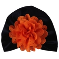 Détail du bonnet turban bébé en velours noir avec une grande fleur orange évidée - Taille unique / Noir