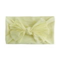 Close-up of soft nylon infant headband featuring a large pale yellow bow detail - Beige
