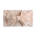 Close-up of soft elastic nylon baby headband with a large pale pink bow detail - Nude Pink