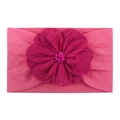 Détail d'un bandeau en nylon pour bébé avec fleur en tissu rose foncé et perles - Rose rouge