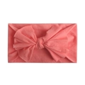 Close-up of coral pink nylon baby headband with a soft oversized bow for infants - Watermelon red