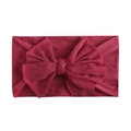 Detail of soft nylon baby headband with large wine red bow on white background - Burgundy
