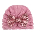 Close-up of pink knitted baby hat featuring a large sequined bow and soft wool texture - Pink