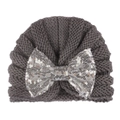 Detail of grey knitted baby hat featuring a large shimmering silver sequin bow - Gray