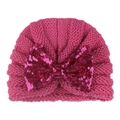 Detailed close-up of rose pink knit baby hat with a sparkling sequined bow decoration - Rose Red