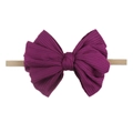 Détail d'un nœud en tissu côtelé violet sur un bandeau élastique pour nourrisson - Pourpre profond