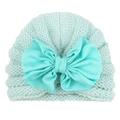 Detail of mint green baby knit hat featuring a large bow and wavy textured patterns - Mint Green
