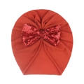 Detailed close-up of a red baby turban hat featuring a large sequined bow decoration - Orange