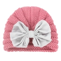 Detail of baby knit hat showing pink woolen texture and large white satin bow accent - Dusky Pink