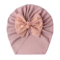 Detail of pink ribbed baby turban hat featuring a gold polka dot bow decoration - Dusky Pink