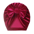 Detail of baby velvet turban hat in magenta featuring a large bow and soft pleated texture - One Size / Fuschia