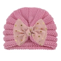 Pink knit baby hat detail showing soft wave texture and gold polka dot bow accent - Pink