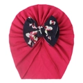 Detail of soft rose red baby turban hat featuring a large navy floral print bow - Rose Red
