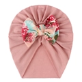 Close-up of baby hat featuring a large floral print bow on soft pink knit fabric - Dusky Pink