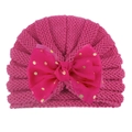 Close-up of pink baby knitted hat featuring a large gold polka dot tulle bow accent - Rose Red