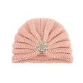 Détail d'un turban en tricot rose pour bébé avec une fleur ornée de perles et strass - Rose chair