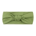 Green ribbed knit elastic headband for baby with cute knot center on white background - Green