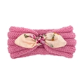 Détail du bandeau tricoté rose pour bébé avec un nœud floral et une maille côtelée - Rose