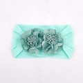 Dettaglio della fascia elastica per neonati verde menta con fiori in tessuto fatti a mano - Verde menta