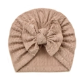 Beige infant knitted turban hat featuring a large soft bow and cable knit texture - Coffee