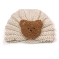 Detailed view of cream baby knitted turban hat with brown plush teddy bear patch - Beige