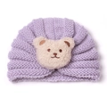 Detail of baby light purple ribbed knit hat with a soft off-white plush bear decoration - Purple