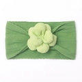 Détail d'un bandeau bébé en nylon avec texture côtelée et fleur en tissu vert herbe - Vert