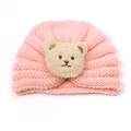 Detailed view of pink knitted baby turban hat with a cute khaki plush bear ornament - Snow Bud