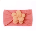 Gros plan sur un bandeau bébé rose corail en nylon souple avec fleur en relief 3D - Rouge pastèque