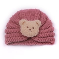 Detail of pink knitted baby hat featuring a cute plush bear embroidery patch - Dusky Pink