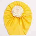 Detail of yellow ribbed knit baby turban featuring a large off-white fabric rose flower - Yellow