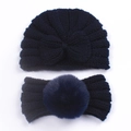 Flat lay detail of navy blue knitted baby hat and headband set with a faux fur pompom - Navy Blue