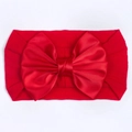 Detailopname van een rode nylon baby haarband met een grote satijnen strik decoratie - Rood