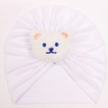 Close-up of baby white turban hat featuring soft pleated fabric and a plush bear detail - White