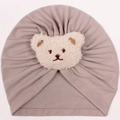 Infant winter beanie in dusty pink with a plush teddy bear face and ribbed knit design - Gray