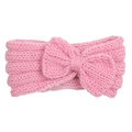 Dettaglio di una fascia rosa lavorata a maglia per neonati con fiocco e trama morbida - Rosa