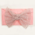 Detail van roze baby haarband met grote glinsterende gaasstrik voor zuigelingen - Roze