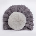 Détail du bonnet en tricot pour bébé gris foncé avec un grand pompon en fausse fourrure crème - Gris
