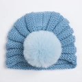 Vue détaillée du bonnet en grosse maille bleue pour bébé avec un grand pompon en fourrure - Bleu